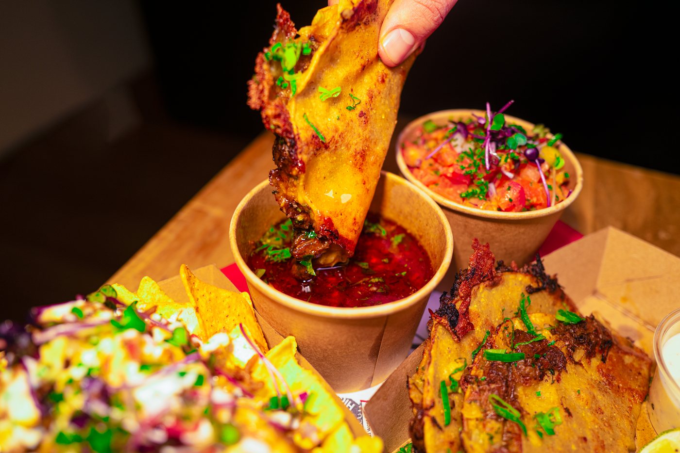 Taco wird beim Catering in die Birria-Brühe getunkt