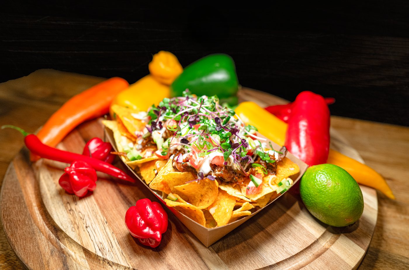 Nachos mit Paprika und Limette auf dem Holzbrett