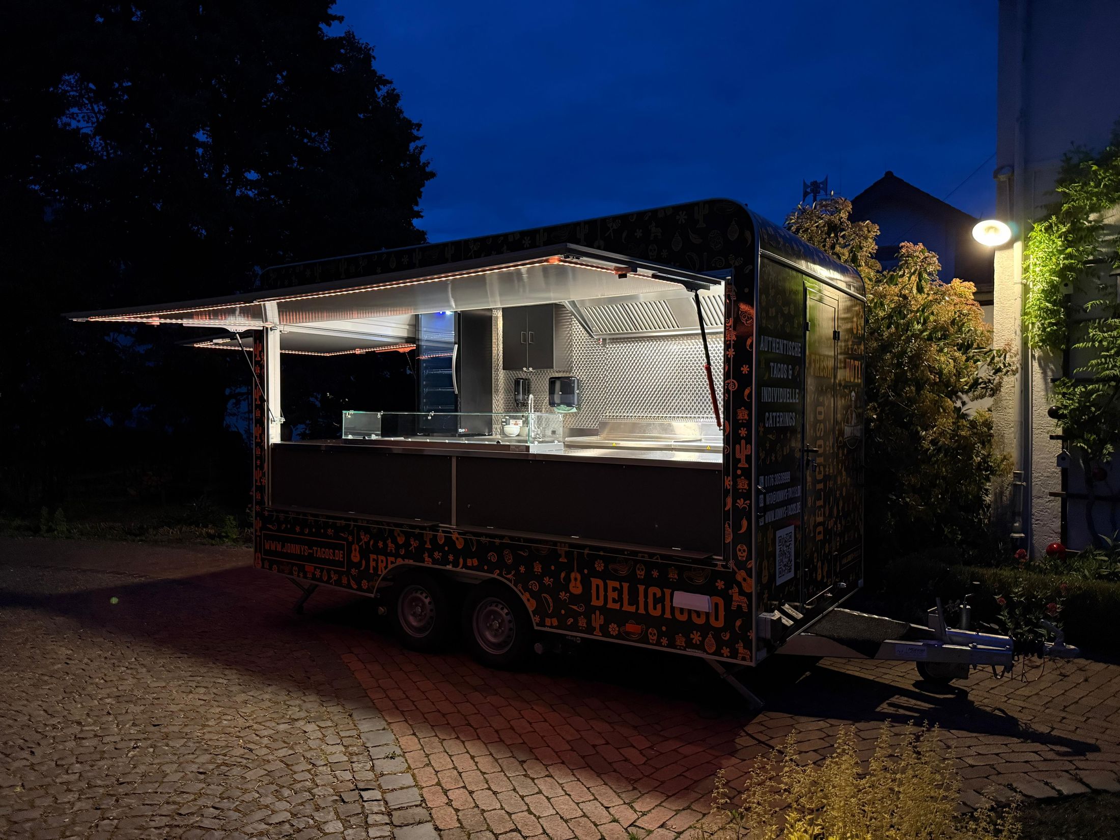 Foodtrailer von Jonny's Tacos in Butzbach bei Nacht mit beleuchteter Ausgabe
